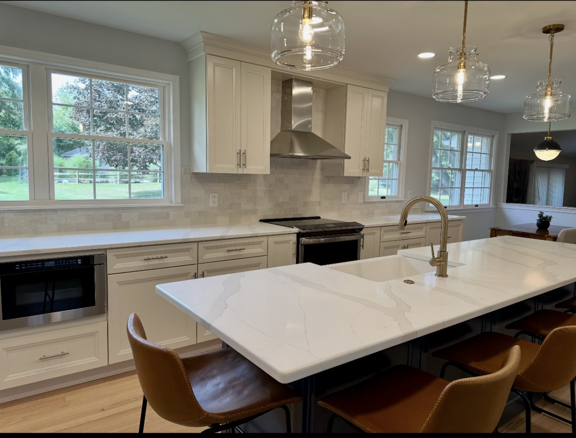 Finished kitchen remodel in Perkasie, PA with a quartz island, cream shaker cabinets, and glass pendant lights